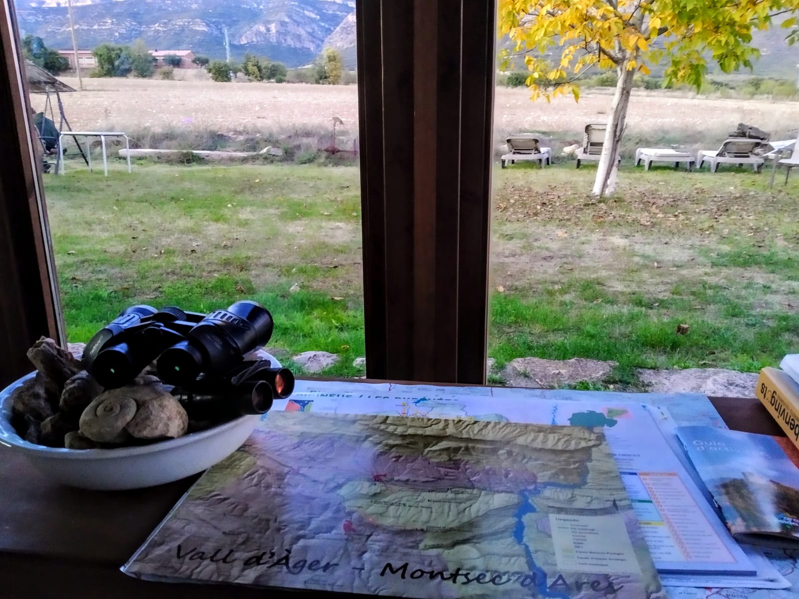 IMG-20191029-WA0026 Finestra amb vistes a un paisatge, a la taula un mapa, sembla que planegen fer turisme rural al cor del Montsec.